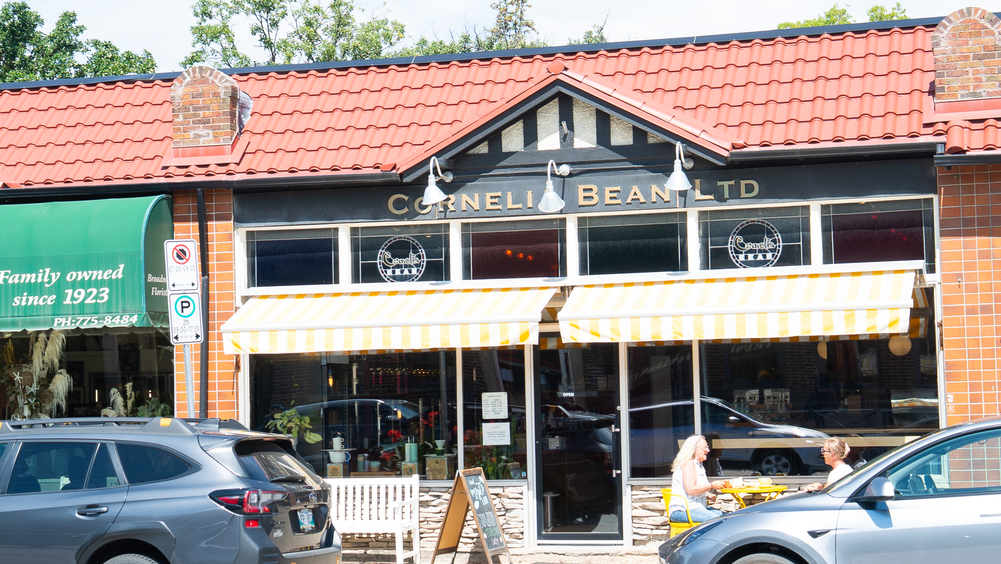 Cornelia Bean Ltd storefront with red tile roof and yellow striped awnings on Academy Road
