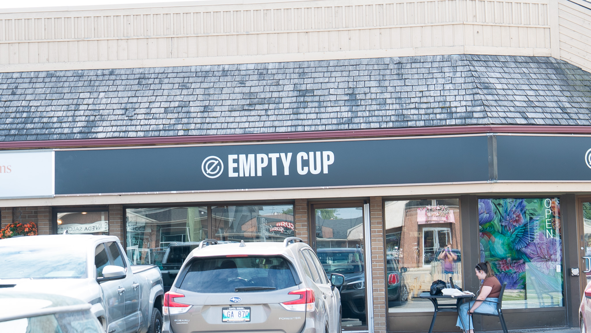 Empty Cup coffee shop storefront with a black awning and shingled roof