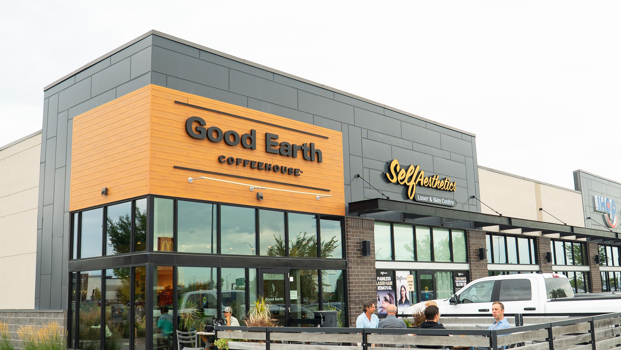 Good Earth Coffeehouse exterior with wood-panelled signage and a patio at Seasons of Tuxedo